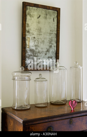 Verre vide sur les bocaux de stockage sous la poitrine en bois miroir en détresse dans l'image Banque D'Images