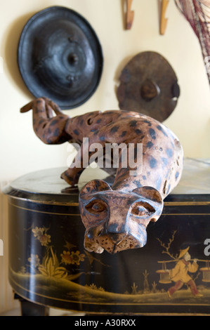 Guépard en bois sculpté au-dessus de grand piano avec boucliers africains dans l'arrière-plan Banque D'Images