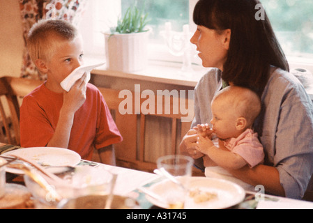 Mère avec des enfants à la table du dîner Banque D'Images