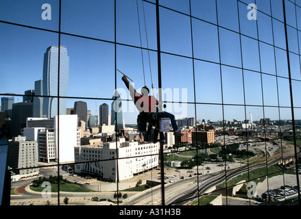 Nettoyant pour vitres travaillant sur un bâtiment élevé dans une écharpe, dallas usa Banque D'Images