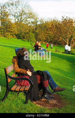 Habillé chaudement choix couple enjoying winter sunshine on park bench Banque D'Images