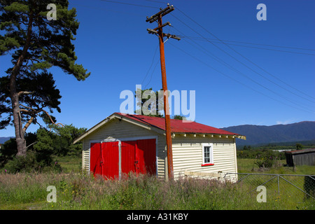 Ancien garage avec portes rouges. Ahaura ponceau, île du Sud, Nouvelle-Zélande. Banque D'Images