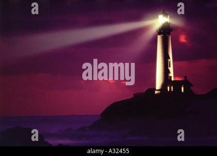 Les faisceaux lumineux rayonnent de Pigeon Point Lighthouse contre dark purple sky at night Californie Banque D'Images