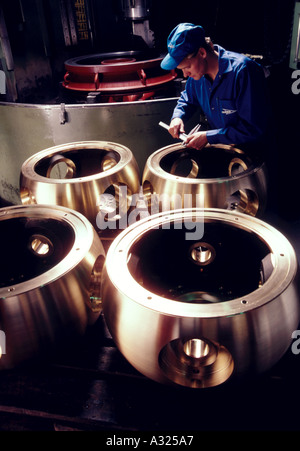 Un technicien travaille sur de grands mâles dans une usine de fabrication de pompes Banque D'Images