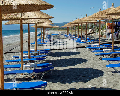 Plage Près de vide par Kokkino Nero avec sund chambres chaises longues et parasols couverts avec des feuilles de palmiers Thessalie Grèce Banque D'Images