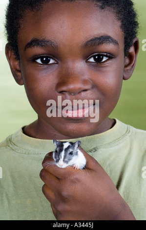 Close up of an African American boy holding une gerbille Banque D'Images