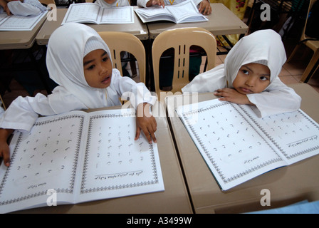 Les élèves de maternelle et primaire une étude d'une version simplifiée du Coran dans une école musulmane, Kuala Lumpur, Malaisie Banque D'Images