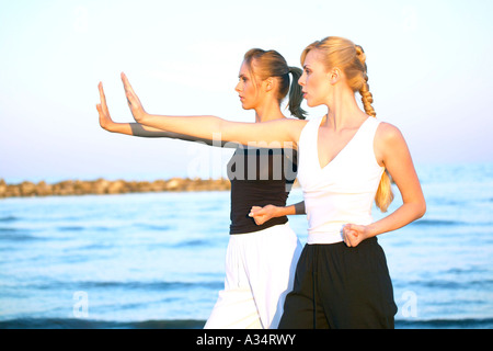 2 Frauen machen Tai Chi Uebungen am Strand, deux femmes faisant de Tai Chi à la plage Banque D'Images