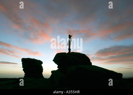 Homme seul figure se tenait sur 'ox' Pierres rochers au lever du soleil à Ringinglow dans le Derbyshire 'Grande-bretagne' Banque D'Images