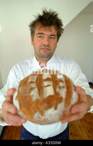 Baker est titulaire d'une miche de pain fraîchement cuit au four Banque D'Images