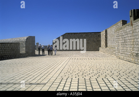 Les touristes dans la distance à la découverte de la ville en pierre du xiiie siècle autour des murs de parapet Dubrovnik Croatie Dalmatie du sud Banque D'Images
