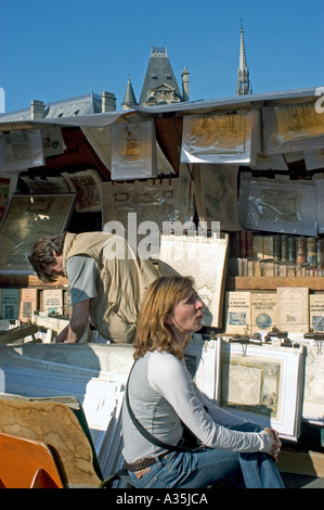 Paris France, magasins couple Shopping aux stands de livres le long de la Seine 'bouquinistes' 'Quai de Montebello' 'Ile de la Cité » Seine librairies Banque D'Images