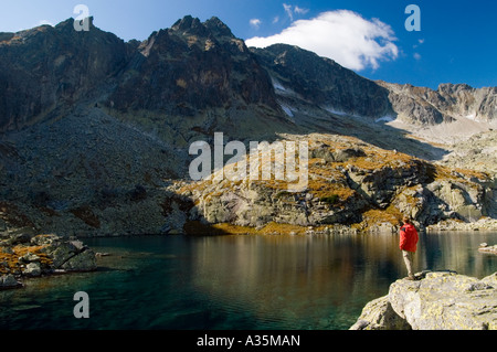 Un touriste en admirant la vue sur un lac de montagne transparente avec le Stit (Ladovy pic de glace) à l'arrière-plan Banque D'Images