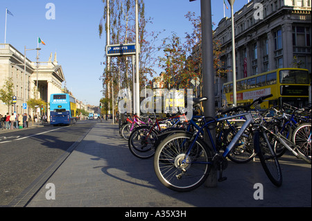 Les vélos garés sur la place au milieu d'O'Connell street en dehors de l'objet Stratégie de groupe avec les bus de Dublin à l'arrière-plan Banque D'Images