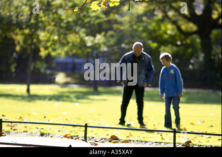 Père et fils jouent au football dans l'herbe à St Stephen's Green Centre-ville de Dublin Banque D'Images