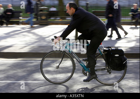 Vélo homme chauve passé sur l'ancien vélo de course avec des sacoches sur route dans un centre-ville Banque D'Images