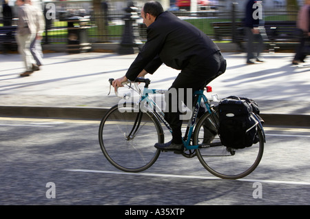 Vélo homme chauve passé sur l'ancien vélo de course avec des sacoches sur route dans un centre-ville vue arrière Banque D'Images