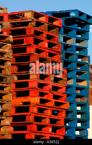 Palettes en bois colorés empilés les uns sur les autres, selon leur couleur. Banque D'Images