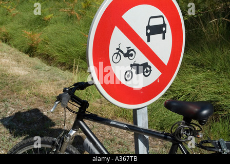 Location garé contre un poteau de signalisation routière Banque D'Images