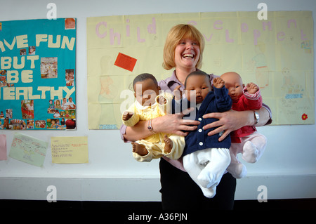 Wendy Stephens un programme Chef d'équipe au Centre de Goschen à plymouth Devon Wendy est représenté avec des bébés Banque D'Images