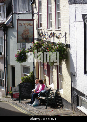 Deux jeunes filles discuter à l'extérieur de la maison publique Dolphin dans Robin Hood's Bay. Banque D'Images