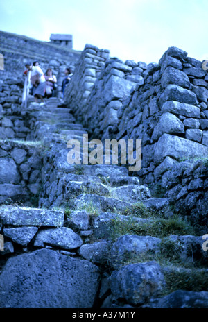 Les touristes marche sur les terrasses agricoles à l'UNESCO World Heritage site de l'ancienne cité inca de Machu Picchu au Pérou Banque D'Images