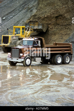 Un nouveau dump truck attend un chargement de gravier sur un chargeur frontal Banque D'Images