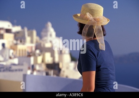 Jeune femme Hat surplombant le village de Firostefani sur l'île de Santorin en Grèce Banque D'Images