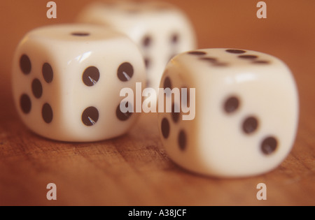 De flou artistique noir repéré trois dés blancs sur une table ou un bureau à la lumière de l'après-midi chaud Banque D'Images