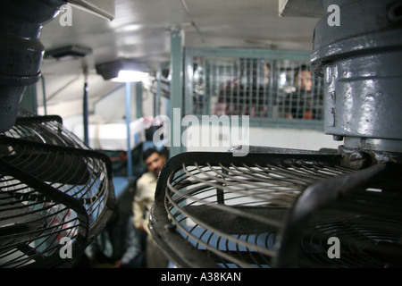 Vue typique de la deuxième classe sleeper transport par les fans dans le lit du haut d'un train dans le Rajasthan, Inde Banque D'Images