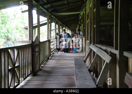 Famille réunis sur le balcon de leur longue maison sur les rives de la Sungai Terika, Sarawak, Bornéo, Malaisie Banque D'Images