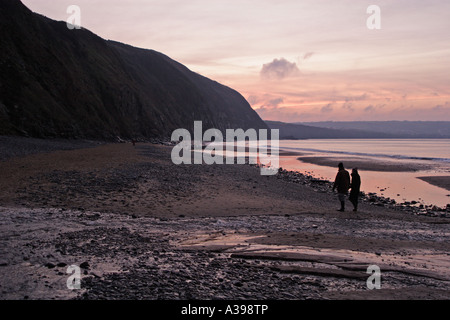 Couple en train de marcher le long de la plage de Penbyrn , Pays de Galles , Grande-Bretagne Banque D'Images