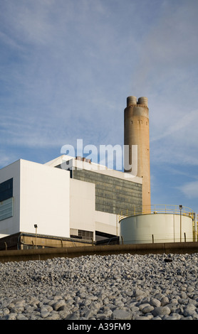 La centrale électrique de Npower désaffectée à Aberthaw, au sud du pays de Galles, avec une plage de galets en premier plan et un ciel bleu derrière avec un nuage léger Banque D'Images