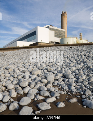 La centrale électrique de Npower désaffectée à Aberthaw, au sud du pays de Galles, avec une plage de galets en premier plan et un ciel bleu derrière avec un nuage léger Banque D'Images