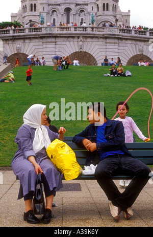 Personne de couleur français man and woman talking in park ci-dessous Sacre-Coeur Basilica Ville de Paris Ile-de-France France Banque D'Images