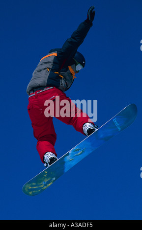 Snowboarder sautant dans la large blue yonder Livigno Italie Banque D'Images