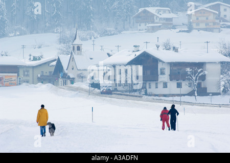 Les skieurs de femme et promener le chien dans la neige ski Mayrhofen Hippach village Vallée du Zillertal Tyrol en Autriche Autriche Banque D'Images