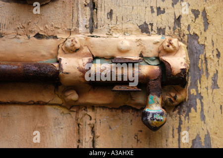 Gros plan d'une porte de l'habitacle avec un vieux faire glisser le boulon de verrouillage de type de peinture écaillée et Rusty Banque D'Images