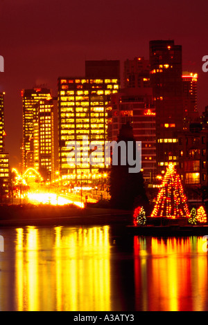 Arbre de Noël et le centre-ville de lumières de 'West End' reflétant dans 'Lost Lagoon', au parc Stanley, Vancouver British Columbia Canada Banque D'Images