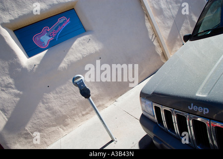 USA New Mexico Santa Fe Blues Club Jeep SUV à côté d'un parcomètre sur trottoirs avec néon guitare Budweiser sign in window Banque D'Images