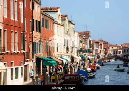 Italie Vénétie Lagune de Venise l'île de Murano, les touristes à pied sur Fondamente dei Vetrai à côté de commerces et canal avec des bateaux amarrés. Banque D'Images