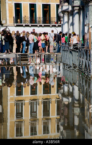 Italie Vénétie Venise Aqua Alta l'injection de l'eau élevé dans la place St Marc. Les touristes entrez l'église basilique sur passerelle soulevées Banque D'Images