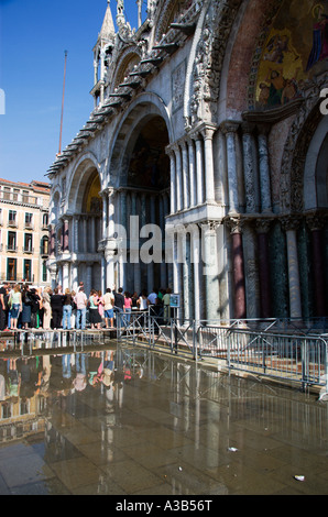 Italie Vénétie Venise Aqua Alta l'injection de l'eau élevé dans la place St Marc. Les touristes entrez l'église basilique sur passerelle soulevées Banque D'Images