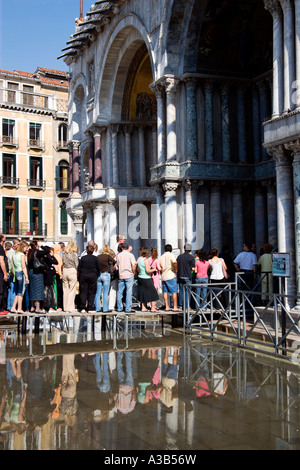 Italie Vénétie Venise Aqua Alta l'injection de l'eau élevé dans la place St Marc. Les touristes entrez l'église basilique sur passerelle soulevées Banque D'Images