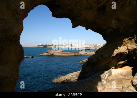 FRANCE Aquitaine Pyrénées Atlantique Basque Biarritz station balnéaire sur la côte atlantique et le phare vu à travers une arche rocheuse. Banque D'Images