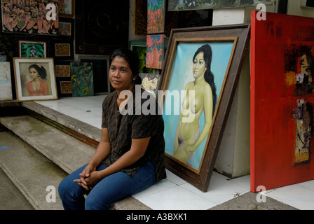 Ubud artiste féminine locale vendant sa propre peinture et d'autres personnes à l'extérieur de son magasin d'art.Bali Indonésie Asie du Sud-est 2006 2000 HOMER SYKES Banque D'Images