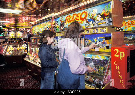 Les filles jouant sur le penny slot machines dans une salle de jeux électroniques, England UK Banque D'Images