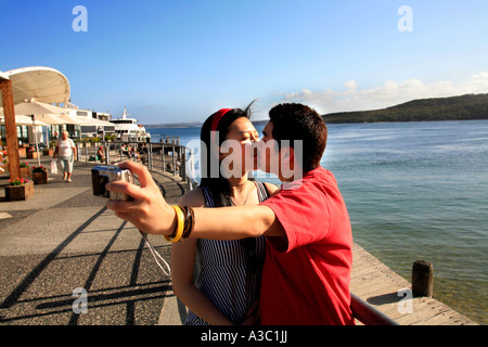 Un jeune couple asiatique baiser tandis qu'ils se photographier après une belle journée à Manly Sydney Australie Banque D'Images