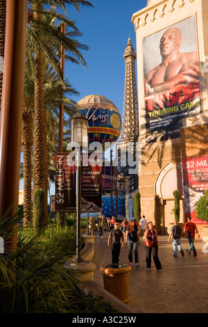 Les touristes déambulant dans les rues de la Bande de Las Vegas sous les palmiers les Paris Casino et un géant de l'affiche de la boxe Banque D'Images