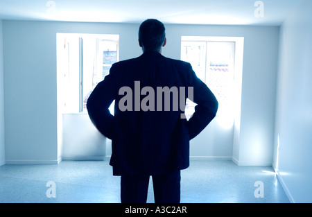 Homme debout dans une salle vide / appartement / chambre - vue arrière silhouette - vente propriété // propriétaire / Location / concept propriétaire Banque D'Images